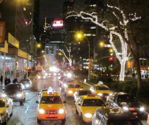 A busy city street with cars and lights at night.