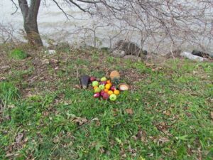 A pile of apples sitting on top of grass.