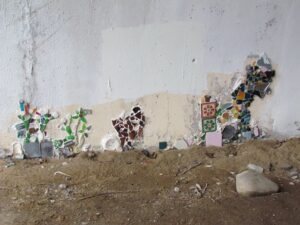 A wall with many different types of broken tiles.