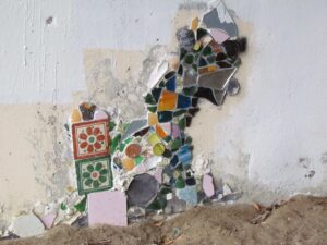 A mosaic of a horse on the side of a wall.
