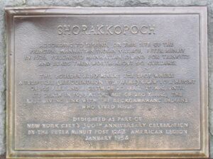 A plaque that is on the side of a building.