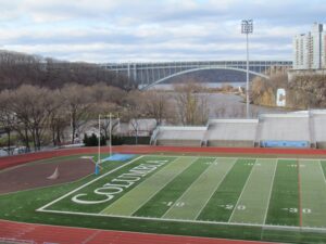 A football field with a view of the bridge.