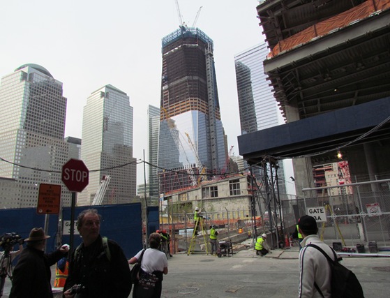 A group of people walking on the street near some buildings.