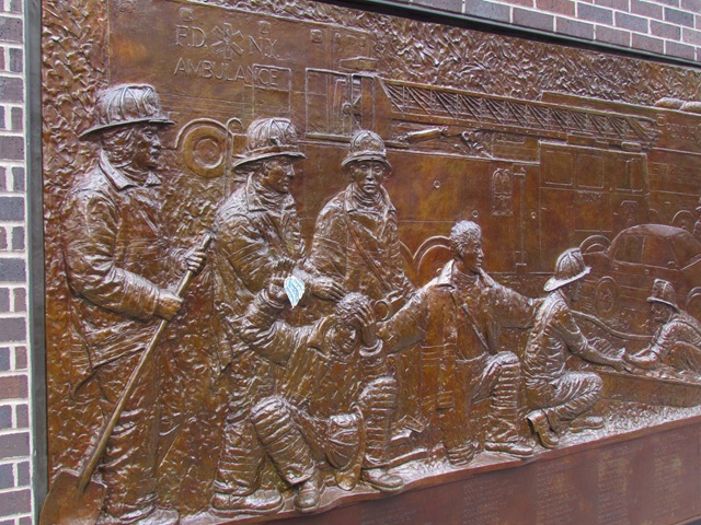 A bronze wall with several people in the middle of it.