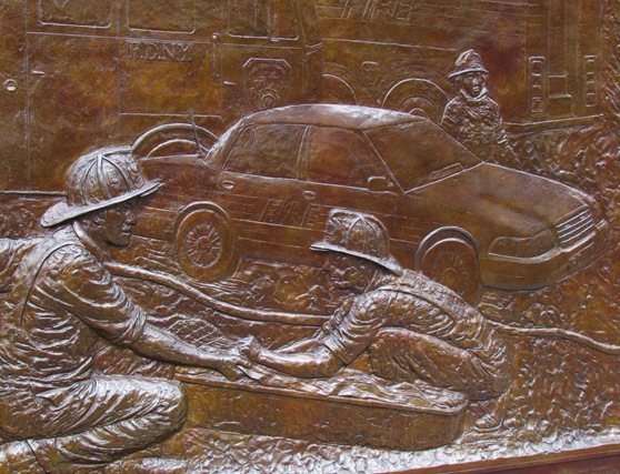 A close up of the bronze relief depicting men in military uniforms.