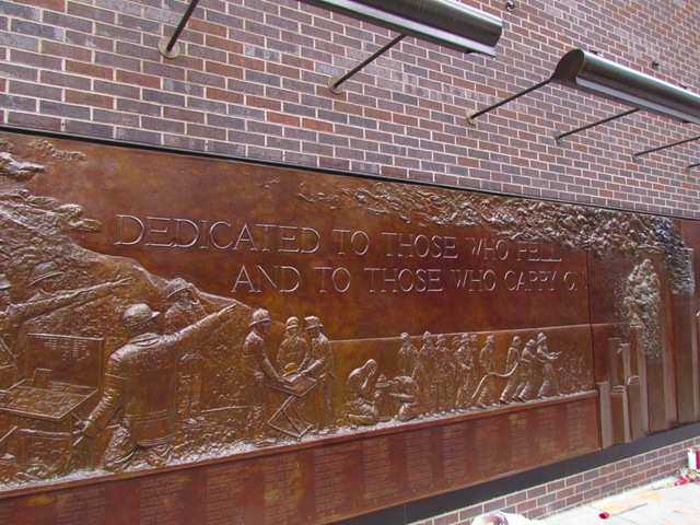 A bronze plaque with the words dedicated to those who served.