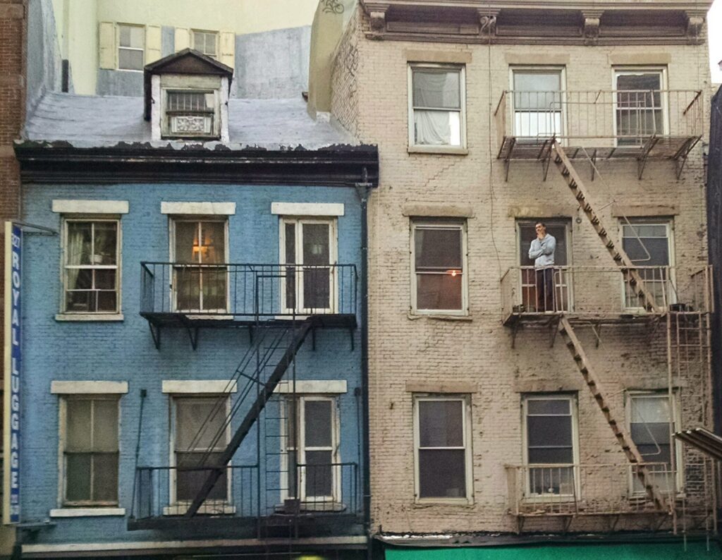 A blue and white building with fire escapes on the side of it.