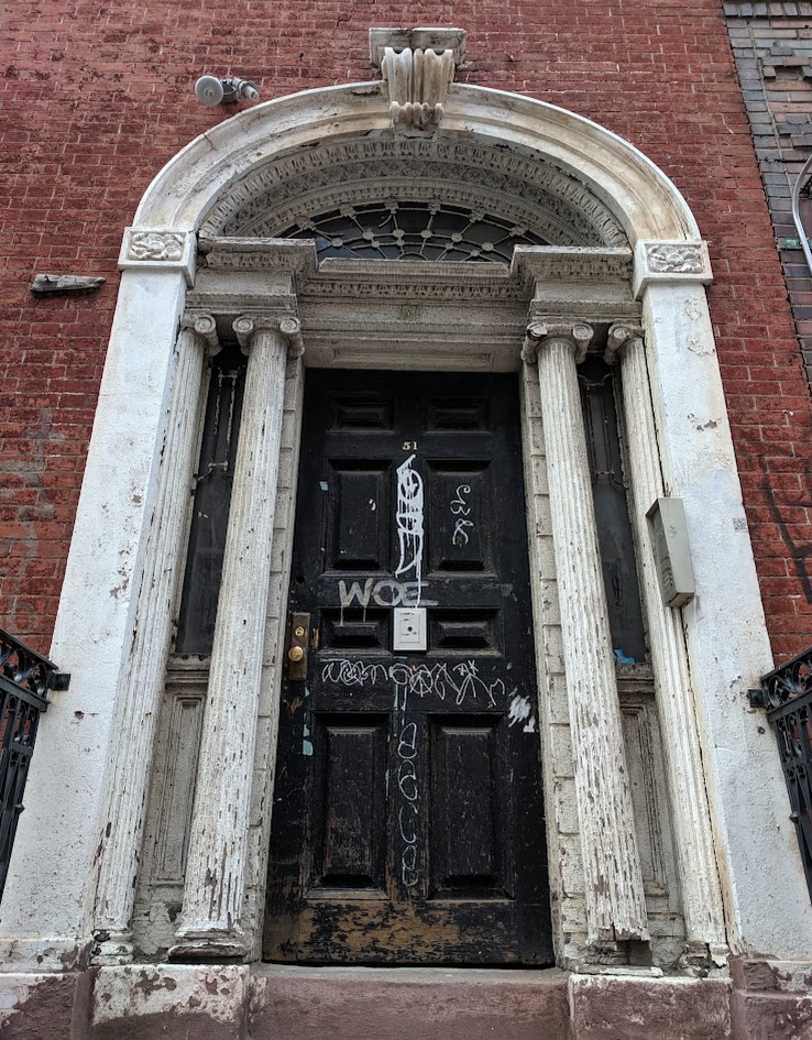 A door that is very old and has graffiti on it.